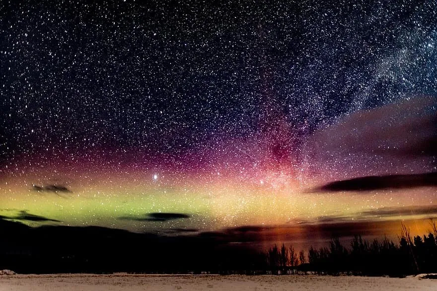 The green glow of the Aurora Borealis over a dark Colorado landscape.